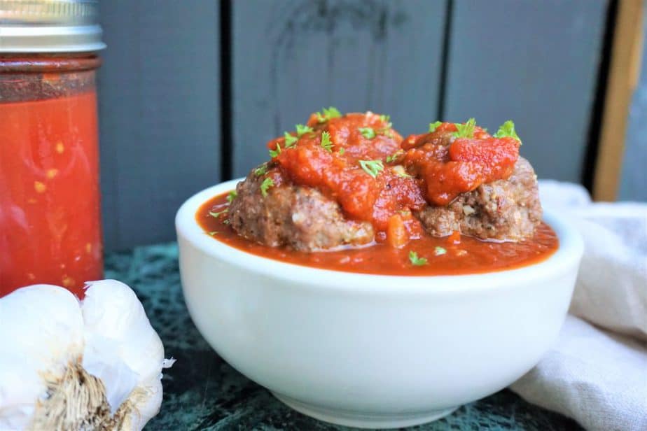 pork and ground beef meatballs sitting on top a of marinara