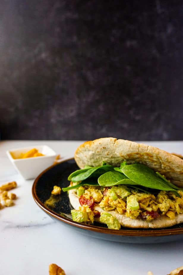 Turmeric spice, walnuts, dried cranberry chicken salad in pita bread with spinach