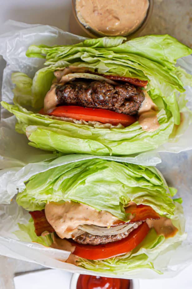 Hamburgers with bacon, tomato, onion, pickles, Animal Sauce and Iceberg Lettuce Buns